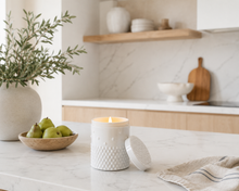 Load image into Gallery viewer, Essence white glass textured soy candle on a kitchen counter with pears and a plant

