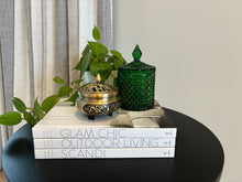 Load image into Gallery viewer, A 250ml soy wax candle in a green geometric-patterned jar on a flat surface, with a white book, a green plant, and a classic French top lid.
